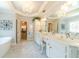 Bright bathroom with white cabinetry, a soaking tub, a double vanity, and marble floors at 1432 Arbor Bluff Ct, Lawrenceville, GA 30045