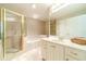 Bright bathroom featuring a large tub, glass enclosed shower, and a white vanity at 1432 Arbor Bluff Ct, Lawrenceville, GA 30045