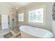 Elegant bathroom featuring a glass shower, soaking tub, and decorative window at 1432 Arbor Bluff Ct, Lawrenceville, GA 30045