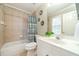 Bright bathroom with a combination tub and shower featuring decoratively tiled walls at 1432 Arbor Bluff Ct, Lawrenceville, GA 30045