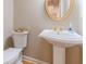 Elegant powder room featuring a pedestal sink, gold fixtures, and a decorative mirror at 1432 Arbor Bluff Ct, Lawrenceville, GA 30045