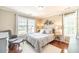 Comfortable bedroom with natural light from two windows with a large decorative bed and chair at 1432 Arbor Bluff Ct, Lawrenceville, GA 30045