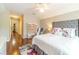 Bright bedroom featuring a ceiling fan, gray upholstered headboard, and hardwood floors at 1432 Arbor Bluff Ct, Lawrenceville, GA 30045