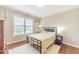Bedroom featuring hardwood floors, a large window, a bed, and two side tables at 1432 Arbor Bluff Ct, Lawrenceville, GA 30045