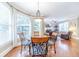 Bright dining area with hardwood floors, large windows, and stylish table and chairs adjacent to living area at 1432 Arbor Bluff Ct, Lawrenceville, GA 30045