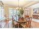 Elegant dining room featuring a large wooden table, chandelier, and ample natural light from the adjacent windows at 1432 Arbor Bluff Ct, Lawrenceville, GA 30045