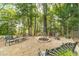 Outdoor stone fire pit with seating surrounded by mature trees, ideal for gatherings at 1432 Arbor Bluff Ct, Lawrenceville, GA 30045