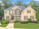 Charming tan two-story home with stone accents, covered porch, and landscaped front yard at 1432 Arbor Bluff Ct, Lawrenceville, GA 30045