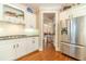 Well-appointed kitchen featuring stainless steel appliances, white cabinetry, granite countertops and wood flooring at 1432 Arbor Bluff Ct, Lawrenceville, GA 30045