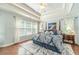 Main bedroom featuring a trey ceiling, multiple windows, and a patterned comforter set at 1432 Arbor Bluff Ct, Lawrenceville, GA 30045