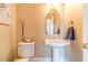 Elegant powder room featuring a pedestal sink, decorative mirror, and charming decor accents at 1432 Arbor Bluff Ct, Lawrenceville, GA 30045