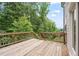 View of wood deck featuring wood railing and views of mature trees and blue skies at 5394 Pebblebrook Se Ln, Mableton, GA 30126