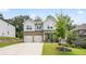 Charming two-story home featuring a manicured lawn, gray siding, and a two-car garage at 5394 Pebblebrook Se Ln, Mableton, GA 30126