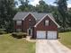 Charming two-story red brick home featuring a two-car garage and well-manicured lawn at 856 Haydens Rdg, Ellenwood, GA 30294