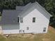 Exterior view of a home featuring white siding, a dark roof, and lush greenery at 856 Haydens Rdg, Ellenwood, GA 30294