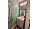 Stylish powder room featuring a vanity, mirror, and unique wall tiles at 856 Haydens Rdg, Ellenwood, GA 30294