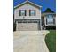 Attractive home featuring a two-car garage, gray stone accents, and a manicured front lawn at 4209 Resheemah St, Atlanta, GA 30349