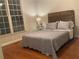 Bedroom with hardwood floors, a decorative wood headboard, and a large window at 727 Pear Grove Pl, Marietta, GA 30066