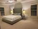 Spacious main bedroom featuring a tray ceiling, plush carpet, and a large upholstered bed frame at 727 Pear Grove Pl, Marietta, GA 30066