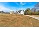 A modern farmhouse sits on a sprawling lot, enhanced by a paved driveway and clear blue skies at 81 Bridgemill Dr, Douglasville, GA 30134