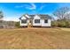 A charming white farmhouse with a well-manicured lawn under a bright blue sky at 81 Bridgemill Dr, Douglasville, GA 30134