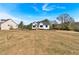 A modern white farmhouse situated on a spacious lot with lush greenery and clear skies at 81 Bridgemill Dr, Douglasville, GA 30134