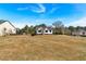 Expansive lot showcases a pristine white farmhouse under a bright blue sky, highlighting its curb appeal at 81 Bridgemill Dr, Douglasville, GA 30134