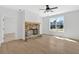 Sunlit living room showcasing a stone fireplace and modern ceiling fan at 81 Bridgemill Dr, Douglasville, GA 30134
