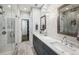 Elegant bathroom featuring double sinks, marble countertops, a glass shower, and access to a walk-in closet at 2447 Figaro Dr, Atlanta, GA 30339