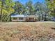 Single-story home features a covered front porch, light colored siding, and a metal roof at 3534 Dahlonega Hwy, Cumming, GA 30028