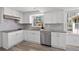 Well-lit kitchen featuring white cabinets, stainless steel appliances, granite countertops and stylish backsplash at 1542 Riderwood Ct, Decatur, GA 30033