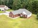 Aerial view of a brick home showcasing a well-maintained lawn and mature trees at 15 Fairwoods Ct, Covington, GA 30016