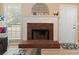 Close up on a red brick fireplace with a white mantel, decorative accents, and natural light from nearby windows at 15 Fairwoods Ct, Covington, GA 30016