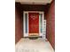 Close-up of a vibrant red front door with sidelights, framed by brickwork and a welcoming sign at 15 Fairwoods Ct, Covington, GA 30016