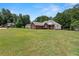 View of a brick home with well-kept lawn, a circular window, and black shutters at 15 Fairwoods Ct, Covington, GA 30016