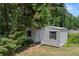 Storage shed with double doors and windows surrounded by greenery at 15 Fairwoods Ct, Covington, GA 30016