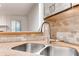 Close-up of a stainless steel kitchen sink with stone tile backsplash and view to living room at 2930 Torreya Way # 2930, Marietta, GA 30067