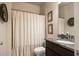 Bathroom featuring granite countertop, dark wood cabinets, and a shower with curtain at 538 Mulberry Fern Dr, Auburn, GA 30011