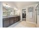 Bathroom featuring dual sink granite countertop vanity, tile floors, and shower at 538 Mulberry Fern Dr, Auburn, GA 30011