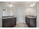 Spacious bathroom featuring dual vanities with dark wood cabinets and granite countertops at 538 Mulberry Fern Dr, Auburn, GA 30011