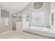Luxurious bathroom featuring shower, garden tub, tile accents, and neutral decor at 538 Mulberry Fern Dr, Auburn, GA 30011