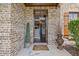 Inviting front entrance with brick facade and a charming welcome mat leading to a view of the interior at 538 Mulberry Fern Dr, Auburn, GA 30011
