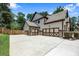 Spacious three-car garage featuring decorative doors and an expansive driveway for additional parking at 538 Mulberry Fern Dr, Auburn, GA 30011