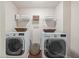 A laundry room equipped with a washer, dryer, shelving, and ample storage space at 538 Mulberry Fern Dr, Auburn, GA 30011