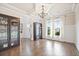 Inviting living room featuring hardwood floors, coffered ceilings, and large windows for ample natural light at 538 Mulberry Fern Dr, Auburn, GA 30011