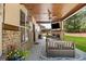 Covered patio with a ceiling fan, a brick fireplace, and outdoor seating with a view of the backyard at 538 Mulberry Fern Dr, Auburn, GA 30011