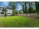 Expansive backyard offers a serene environment surrounded by lush greenery and a wooden fence; home with a balcony at 833 Humphries Sw St, Atlanta, GA 30310