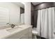 Modern bathroom features a stylish vanity, spacious shower with dark tile surround and pristine white shower curtain at 833 Humphries Sw St, Atlanta, GA 30310