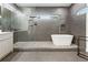 Bathroom featuring a modern tub, glass-enclosed shower, and gray tiled walls at 833 Humphries Sw St, Atlanta, GA 30310