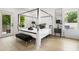 Stylish bedroom featuring a black canopy bed and a view of green trees outside the door at 833 Humphries Sw St, Atlanta, GA 30310